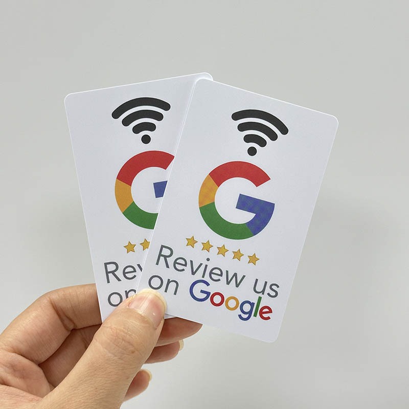 Hand holding two 'Review us on Google' tap cards